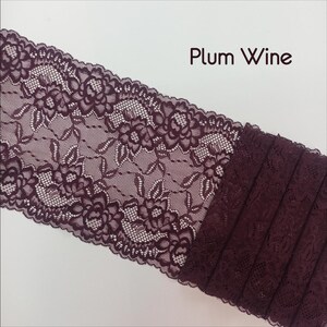 May include: Plum Wine colored lace trim with a floral pattern. The lace is folded and stacked to show the depth of the color.
