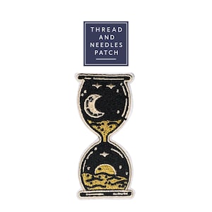 May include: Embroidered patch with a black hourglass design, featuring a crescent moon and stars at the top and a sunset at the bottom. The patch has gold and white accents and the text "THREAD AND NEEDLES PATCH" in a navy blue rectangle.