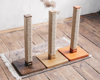May include: Three cat scratching posts with different colored bases. The posts are wrapped in natural sisal rope and the bases are made of wood. The bases are brown, light brown, and orange.