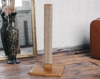 May include: A natural sisal rope cat scratching post with a wooden base. The post is wrapped in natural sisal rope and has a square wooden base.