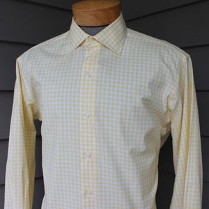 May include: A yellow and white gingham long-sleeve button-down shirt.