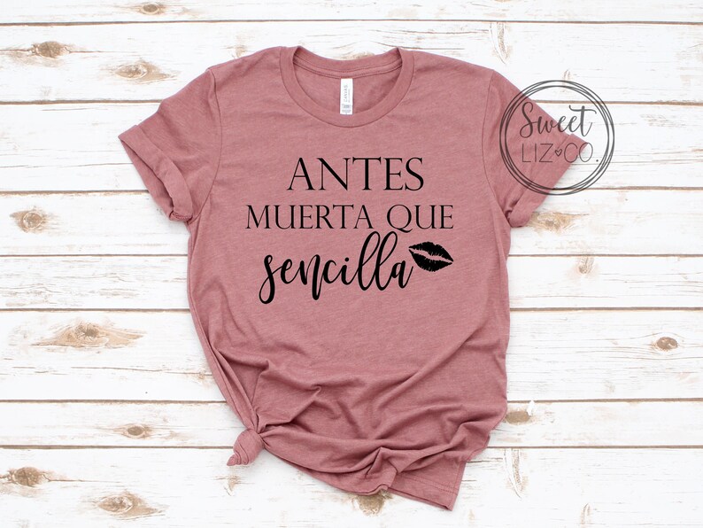 May include: A mauve t-shirt with the text "Antes Muerta Que Sencilla" and a black lip print.