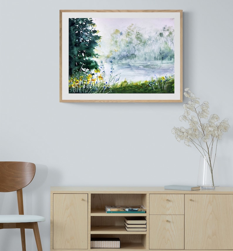 May include: A watercolor painting of a lake scene with a forest in the background. The lake is calm and the water is a light blue color. The forest is a dark green color and the trees are tall and slender. There are some yellow flowers in the foreground.
