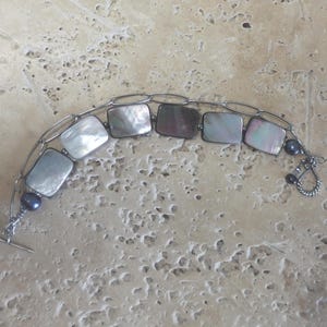 May include: A set of three ceramic mugs with a speckled, matte finish. The mugs are in shades of cream, light gray, and dark gray. Each mug has a simple, minimalist design, perfect for coffee or tea.