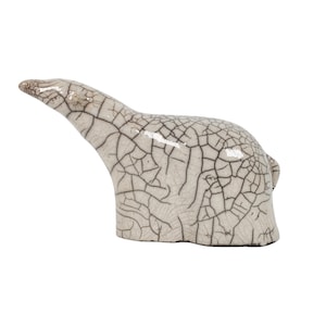 May include: A white ceramic sculpture of a stylised animal with a cracked glaze finish.