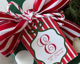 Könnte beinhalten: Ein Weihnachtsgeschenk, verpackt in grünem Papier mit weißen Punkten, gebunden mit einem rot-weiß gestreiften Band. Ein Geschenkanhänger mit roten Streifen und dem Text "Merry Christmas The Edwards" ist angebracht.