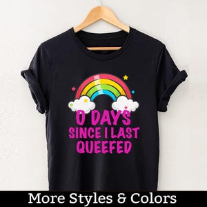 Puede incluir: Camiseta negra con un arcoíris y el texto "0 Days Since I Last Queefed" en rosa.