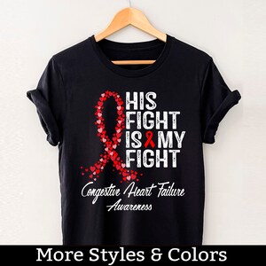 May include: Black t-shirt with a red ribbon made of hearts and the text "His Fight Is My Fight" and "Congestive Heart Failure Awareness".