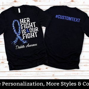 May include: Black t-shirt with a blue ribbon and hearts design. The text on the shirt reads "Her Fight Is Our Fight" and "Diabetes Awareness". The back of the shirt has the text "#CUSTOMTEXT".