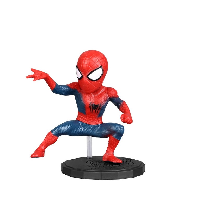 Peut inclure: Une figurine de Spider-Man rouge et bleue en position accroupie, les bras tendus. La figurine est sur une base noire avec un motif de toile d'araign&eacute;e.