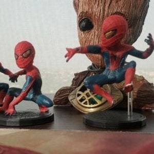 Peut inclure: Quatre figurines de Spider-Man rouges et bleues, chacune dans une pose diff&eacute;rente. Les figurines sont pos&eacute;es sur des socles noirs avec un logo Spider-Man blanc.