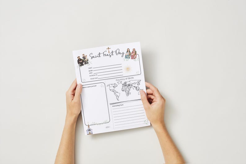 Puede incluir: Un papel blanco con el texto "Saint Feast Day" e ilustraciones de personas, una cruz y una iglesia. El papel incluye secciones para informaci&oacute;n personal, un mapa del mundo y espacio para notas. El papel est&aacute; sostenido por dos manos.