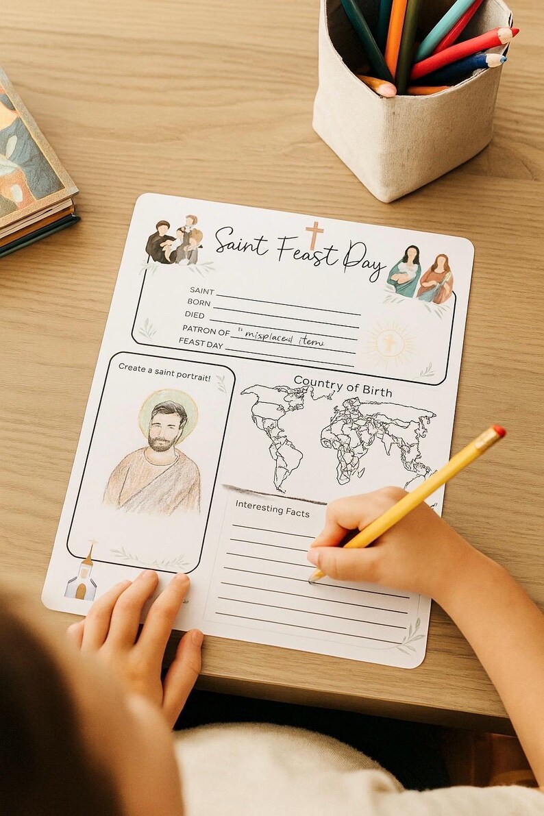 Puede incluir: Una hoja de trabajo blanca de Saint Feast Day con ilustraciones y texto. La hoja de trabajo incluye secciones para un retrato de santo, un mapa del pa&iacute;s de nacimiento y datos interesantes. Un ni&ntilde;o usa un l&aacute;piz amarillo para escribir.