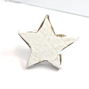 May include: A distressed, white-painted wooden star. The five-pointed star has a rustic appearance with visible wood grain and a gold-coloured edge. Suitable for festive decorations or craft activities.