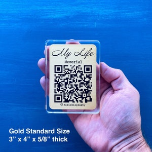 May include: A gold-coloured acrylic plaque with a black QR code and the text "My Life Memorial Audiobiography" in black script. The plaque is 3 inches by 4 inches and 5/8 inch thick.