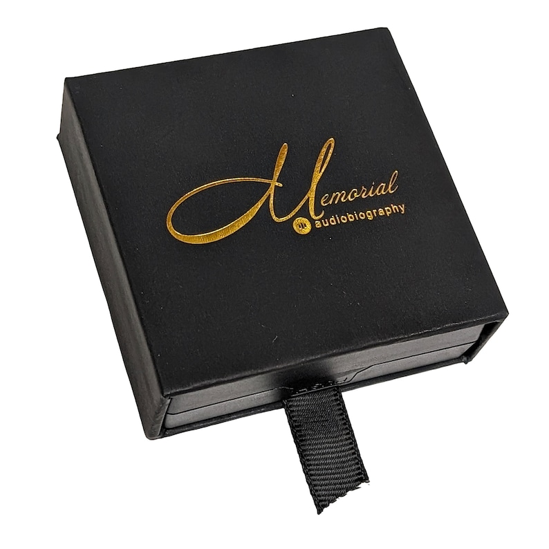 May include: Black box with a gold inscription that reads "Memorial Audiobiography". The box has a black ribbon.