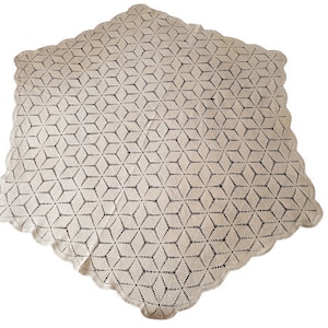 Può includere: Una tovaglia quadrata all'uncinetto color crema con un motivo geometrico a stella. I bordi sono smerlati, aggiungendo un tocco decorativo. Questo tessuto fatto a mano è adatto per un tavolo da pranzo o come elemento decorativo.