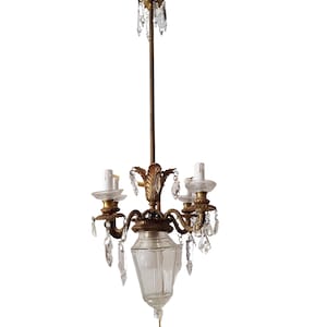 Könnte beinhalten: Ein goldfarbener Kronleuchter mit drei Lichtern und Kristall-Akzenten. Der Kronleuchter hat einen klaren Glasschirm und ein dekoratives Design.