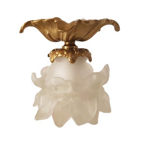 May include: A decorative ceiling light fixture with a floral design. The fixture has a gold-coloured, petal-shaped top and a frosted glass shade shaped like a flower. The light fixture is designed to be mounted on a ceiling.
