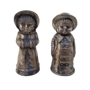 Vintage set of spices. Shaker for salt and pepper. Metal figurines of children. Boy and girl.
