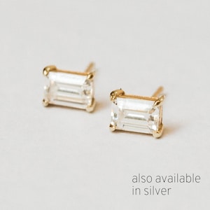 May include: A pair of gold earrings with emerald cut clear stones. Also available in silver.