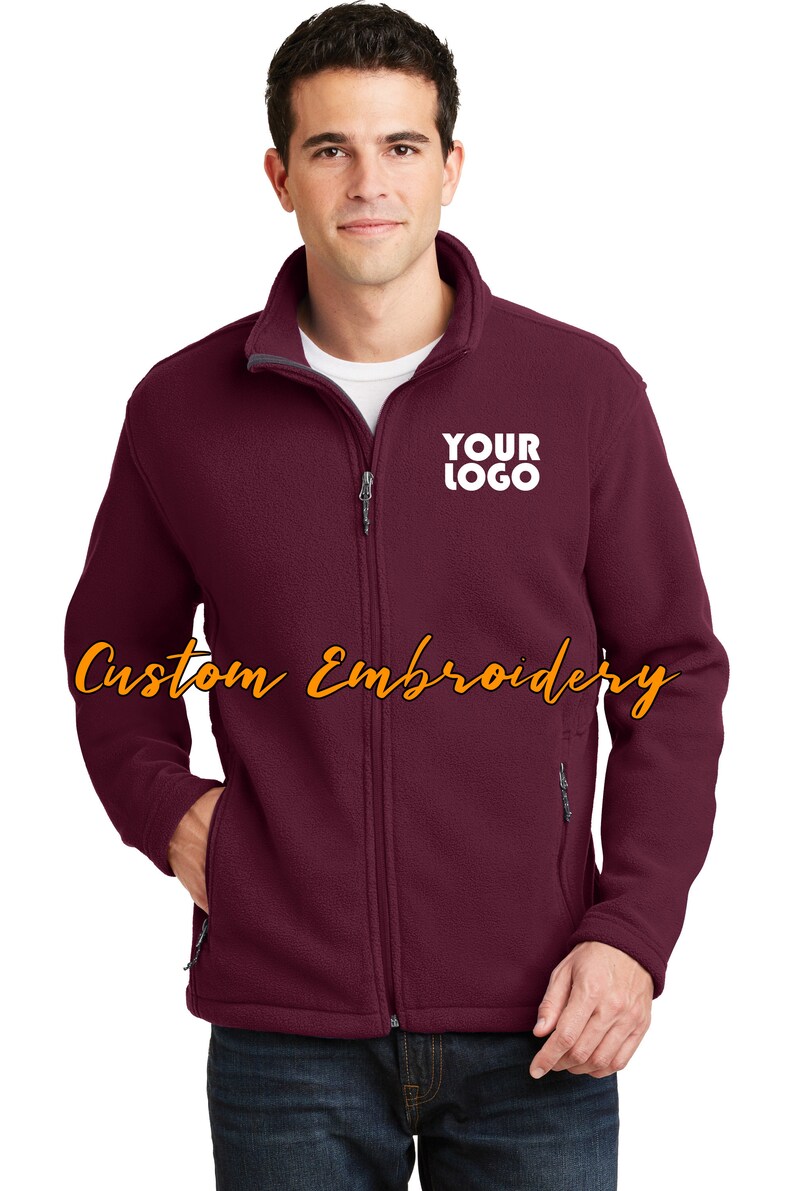 May include: Burgundy fleece zip-up jacket with a gray zipper and a white embroidered logo that says "YOUR LOGO".