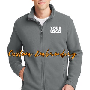 May include: A gray fleece jacket with a zipper closure and two front pockets. The jacket has a white embroidered logo that says "YOUR LOGO" on the left chest.