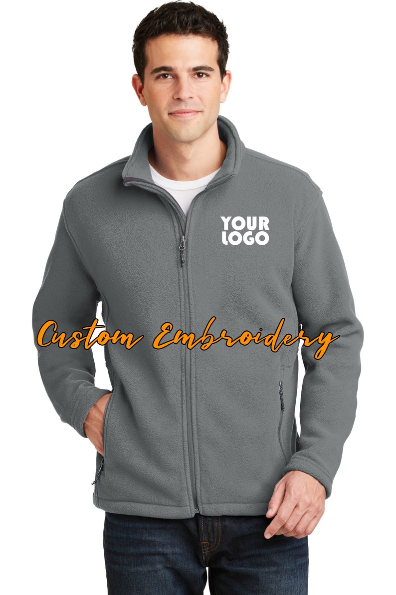 May include: A gray fleece jacket with a zipper closure and two front pockets. The jacket has a white embroidered logo that says "YOUR LOGO" on the left chest.