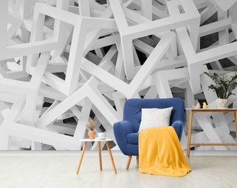 May include: A blue armchair with a yellow throw blanket and a white pillow sits in front of a white geometric wall mural. A small wooden table with a plant and a cup sits next to the chair.