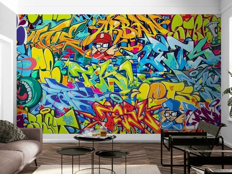Puede incluir: Un vibrante mural de graffiti con letras abstractas coloridas y personajes de dibujos animados. La obra de arte utiliza una paleta de azules, amarillos, naranjas y verdes. El dise&ntilde;o se aplica a una pared.