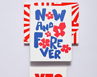 May include: Two white cards with red and blue text. The top card says "Now And Forever" with red flowers and blue text. The bottom card says "Yes" in red text.