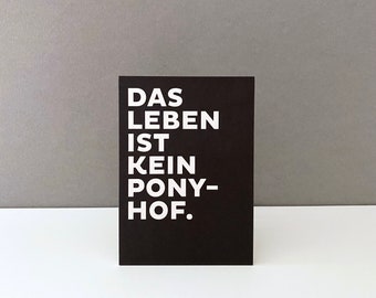 May include: Black card with white text that reads "Das Leben ist kein Pony-Hof."