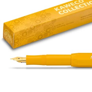 Op de afbeelding: Een gele vulpen met een gouden penpunt en de tekst "Kaweco Collection" gedrukt op de zijkant. De pen zit in een gele doos met een honingraatpatroon en de tekst "Kaweco Collection" gedrukt op de bovenkant.