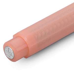 May include: Close-up of a peach-colored pen. The pen's body is a solid, matte finish, with a rounded tip. The pen's end cap features a silver emblem. The pen is angled diagonally against a white background.