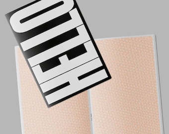 May include: A black and white notebook with the word "HELLO" in large white letters. The open notebook has a peach-colored patterned design on the inside pages. The notebook is open, with the cover slightly angled.