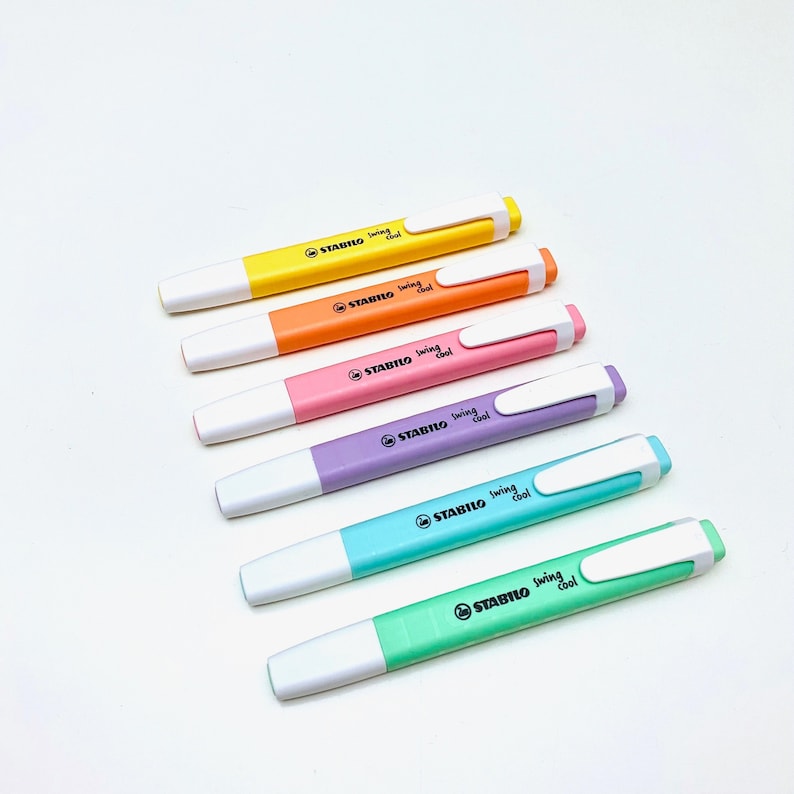 以下が含まれることがあります： 黄色、オレンジ、ピンク、紫、青、緑の6色のSTABILO swing cool蛍光ペン。各蛍光ペンには白いペン先と白いクリップが付いています。各蛍光ペンには「STABILO swing cool」の文字が印刷されています。