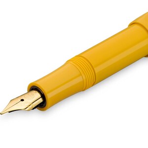 Op de afbeelding: Een gele vulpen met een gouden penpunt. De pen heeft een eenvoudig ontwerp en een gladde, glanzende afwerking.