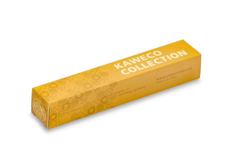 Op de afbeelding: Een gele doos met een honingraatpatroon en de tekst "KAWECO COLLECTION" aan de bovenkant. De doos heeft ook de tekst "Brand No. 11, 90431 Nuremberg, Germany" en "www.kaweco-pen.com Made in Germany" aan de onderkant.