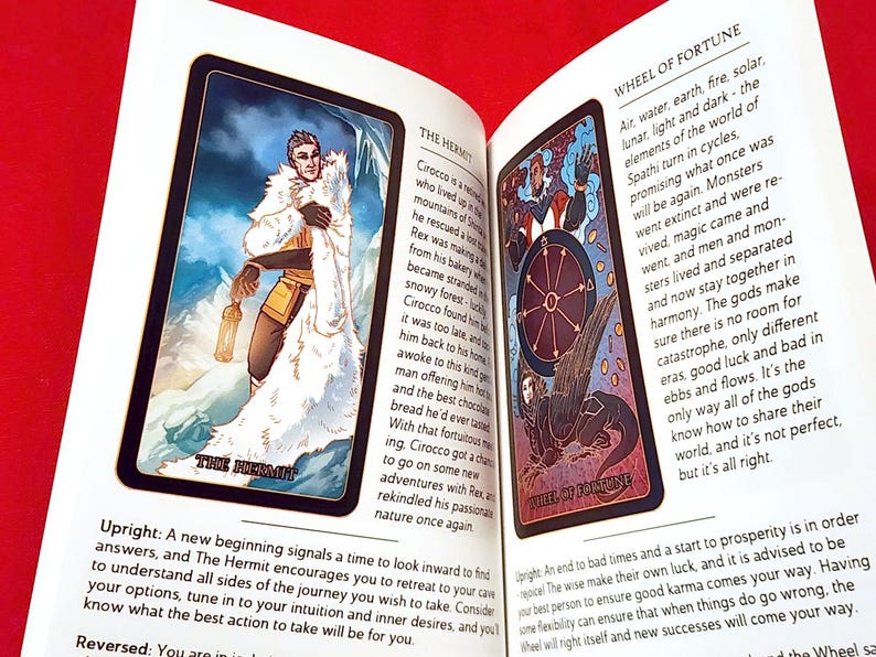 May include: Two tarot cards, The Hermit and Wheel of Fortune, with illustrations and descriptions. The Hermit card shows a man in a white hooded cloak standing in a snowy landscape. The Wheel of Fortune card shows a winged creature with a wheel in the center.