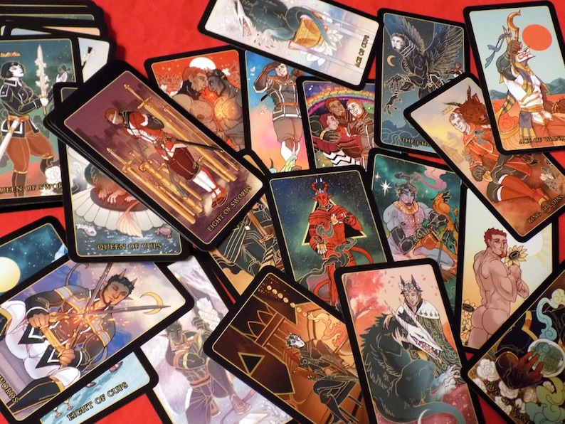 May include: A spread of tarot cards with black borders and gold accents. The cards feature colorful illustrations of people, animals, and symbols. The cards are laid out on a red surface.