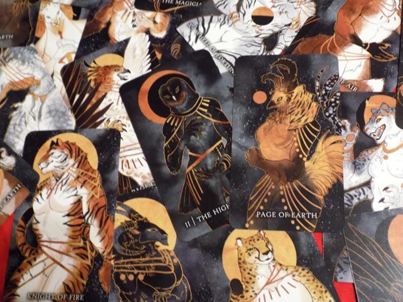 Puede incluir: Un juego de cartas de tarot con fondos negros y detalles dorados. Las cartas presentan ilustraciones de animales y criaturas m&iacute;ticas. Las cartas est&aacute;n dispuestas en un orden aleatorio. Las cartas forman parte de una baraja de tarot.