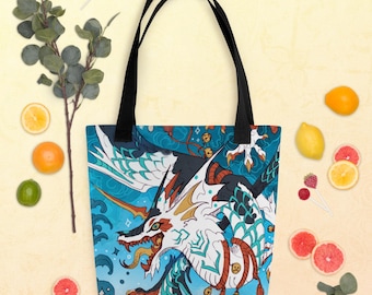 Può includere: Una borsa tote blu e bianca con un design di drago colorato. Il drago ha squame rosse, bianche e nere ed è circondato da nuvole blu e bianche. La borsa ha spalline nere.
