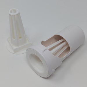 May include: Two-piece white plastic device. One piece is a cylindrical container with a cut-out section revealing three internal rods. The other piece is a cone-shaped structure with vertical supports and a square base. The items are on a white surface.