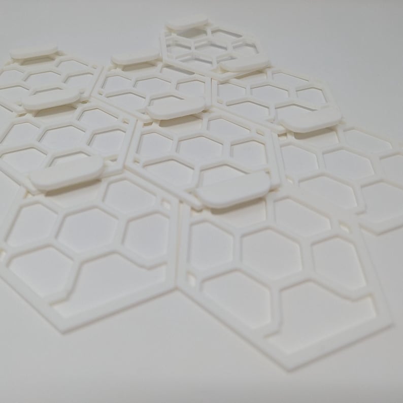 May include: White honeycomb-shaped tiles made of plastic. The tiles are arranged in a staggered pattern, creating a three-dimensional effect.