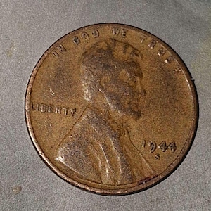 Puede incluir: Un centavo estadounidense de cobre de 1944 con las palabras "In God We Trust" y "Liberty" visibles. La moneda tiene un perfil de Abraham Lincoln en el anverso.