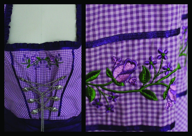 May include: A purple and white checkered bodice with embroidered floral details. The bodice features a silver chain closure and is trimmed with dark purple fabric. The embroidery includes purple roses and green leaves, creating a traditional aesthetic.