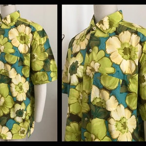 Puede incluir: Una camisa de manga corta con botones y un estampado floral grande en tonos verdes, amarillos y azules.