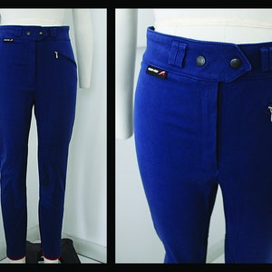 Op de afbeelding: Blauwe broek met hoge taille, met een ritszak aan de rechterkant en een knoopsluiting. De broek heeft een rode zoom aan de onderkant.