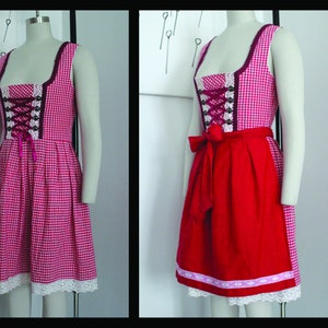 Peut inclure: Une robe de dirndl en vichy rouge et blanc avec un corsage bordeaux et une bordure en dentelle blanche. La robe a un tablier rouge avec une bordure en dentelle blanche et un n&oelig;ud bordeaux.