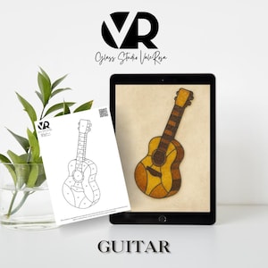 May include: A digital tablet displays a stained glass guitar design in shades of brown and yellow. A printed outline of the guitar is next to the tablet. The image includes the text "VR Glass Studio Vale Rosa" and the word "GUITAR".